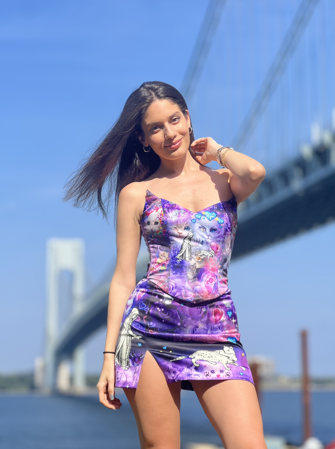 Tya photographed outdoors against a bridge and blue sky